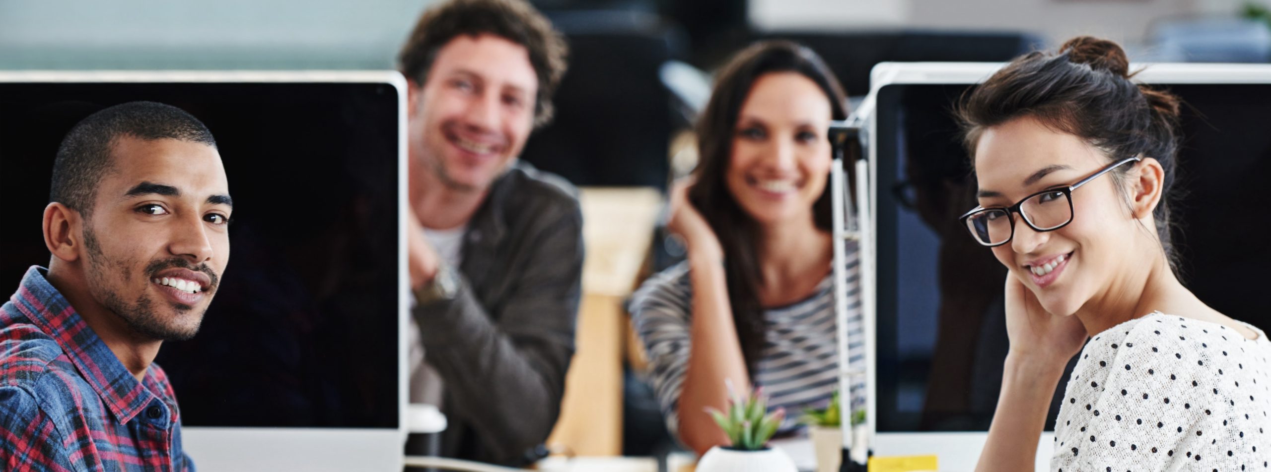Portrait of a group of young office workers sitting at their computers